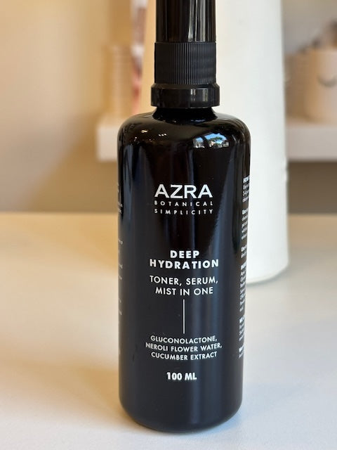 Black bottle of AZRA Deep Hydration skincare product on a light surface